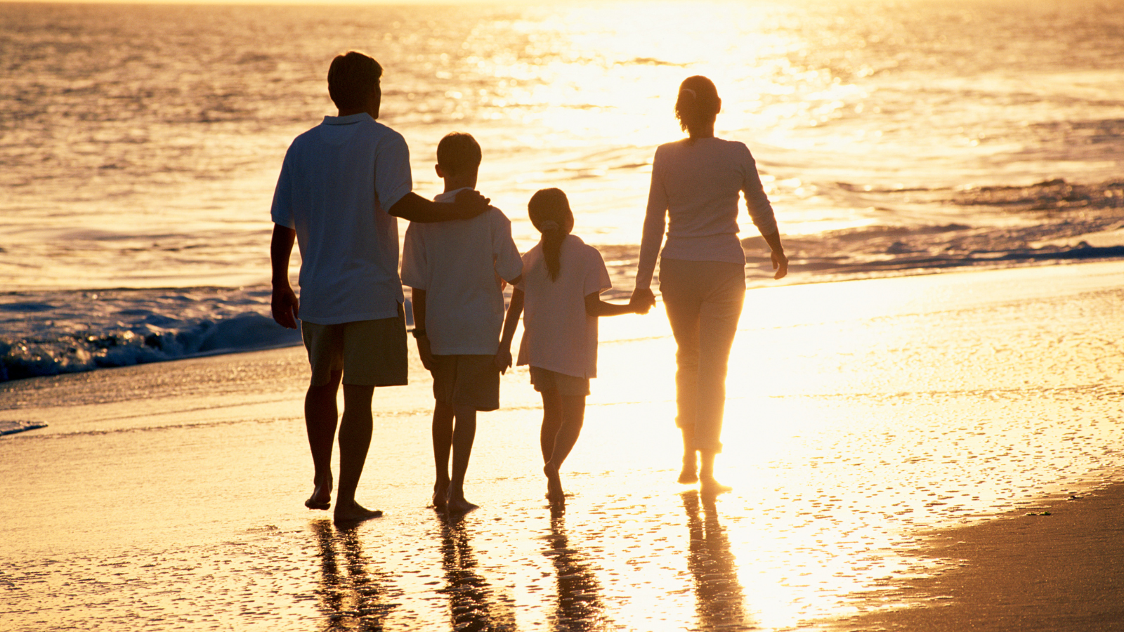 Family watching the sunset next to the sea